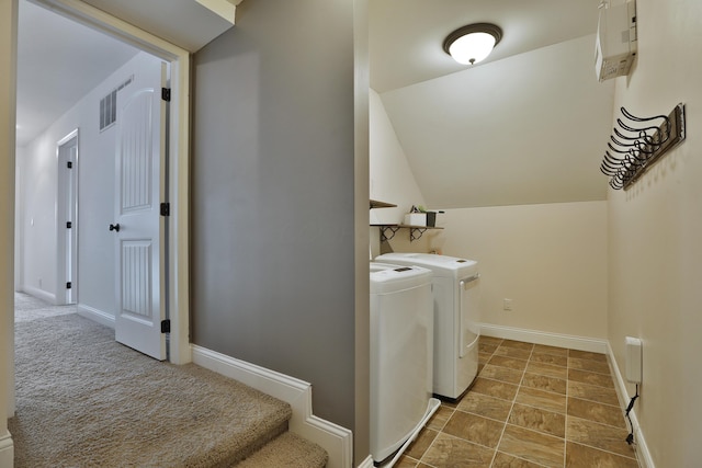 laundry area featuring visible vents, baseboards, laundry area, washer and clothes dryer, and stone finish flooring