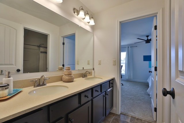 full bathroom with double vanity, a sink, and baseboards