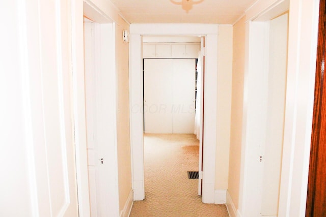 hall with light colored carpet and baseboards