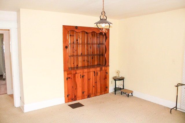 spare room featuring visible vents, baseboards, and carpet