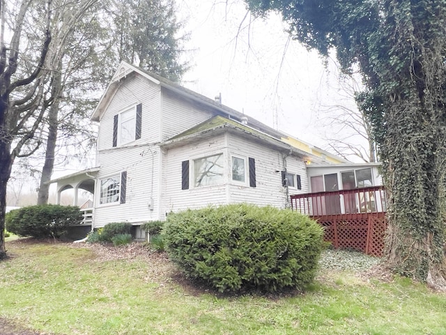 back of house with a sunroom and a lawn