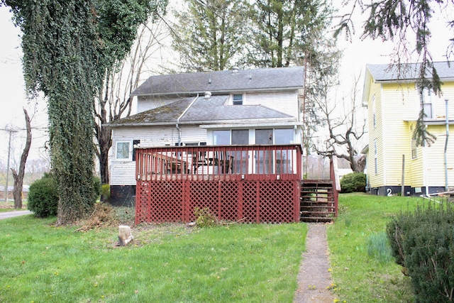 back of property with a deck and a lawn