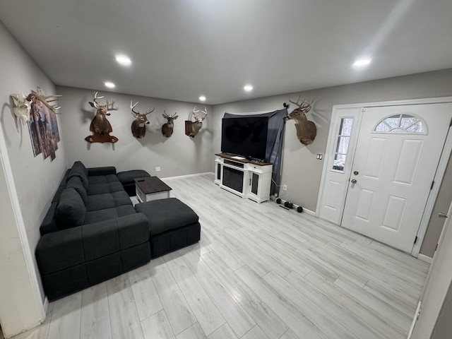 living area featuring light wood-style floors, baseboards, and recessed lighting