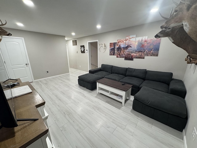 living room with recessed lighting, baseboards, visible vents, and light wood-style floors