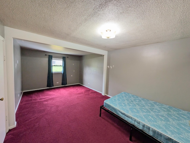 carpeted bedroom with a textured ceiling and baseboards