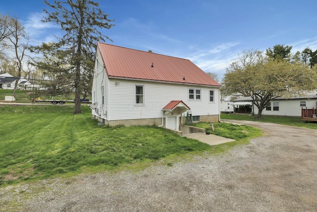 back of property featuring a yard and metal roof