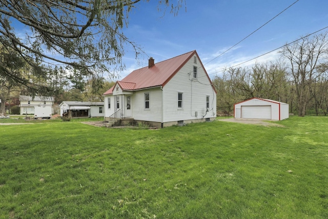 view of side of property featuring an outbuilding, a detached garage, entry steps, metal roof, and a chimney