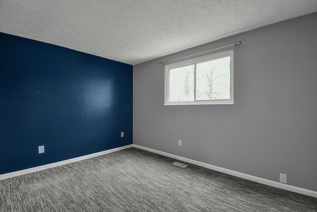 carpeted empty room featuring visible vents, a textured ceiling, and baseboards