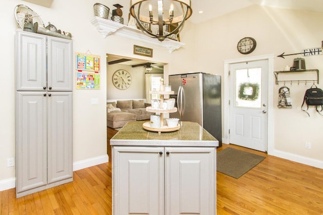 kitchen featuring baseboards, light wood finished floors, and stainless steel refrigerator with ice dispenser