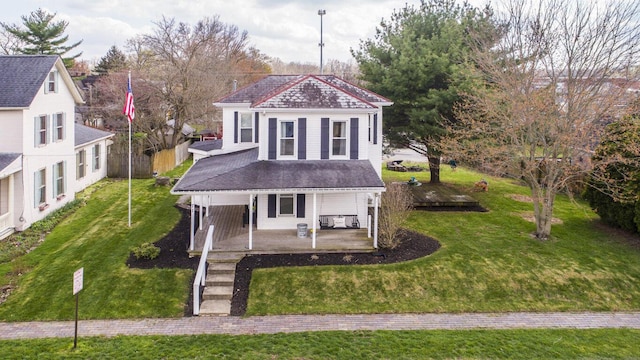 view of front of property with a front yard, a shingled roof, and a patio area
