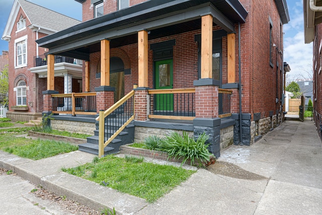 344 E Whittier St, Columbus, OH 43206 - doorway to property featuring concrete driveway, a porch, and brick siding