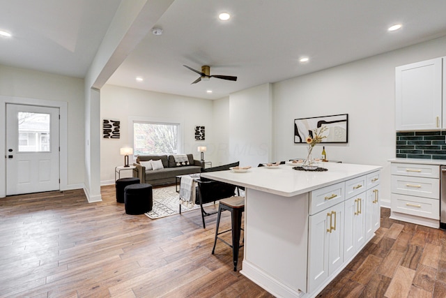 344 E Whittier St, Columbus, OH 43206 - kitchen featuring a breakfast bar area, light countertops, a kitchen island, white cabinetry, and a ceiling fan