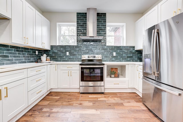 344 E Whittier St, Columbus, OH 43206 - kitchen with appliances with stainless steel finishes, a healthy amount of sunlight, wall chimney range hood, and white cabinetry
