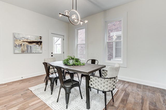 344 E Whittier St, Columbus, OH 43206 - dining space featuring light wood-style flooring, a chandelier, and baseboards