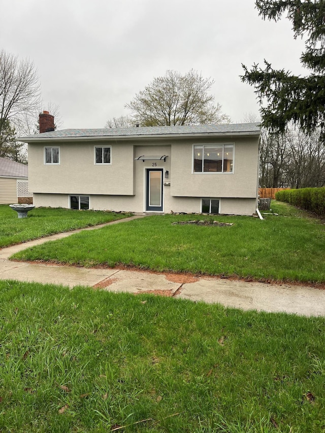 bi-level home featuring a front yard and a chimney