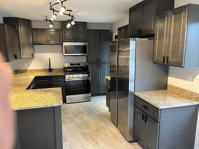 kitchen with light stone counters, marble finish floor, a sink, and stainless steel appliances