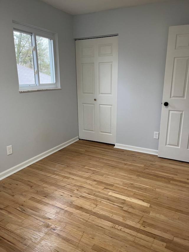 unfurnished bedroom featuring light wood-style floors and baseboards