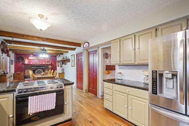 kitchen with ceiling fan, a textured ceiling, cream cabinetry, light wood finished floors, and stainless steel appliances