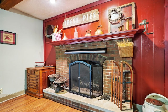 details with wood finished floors, baseboards, and a brick fireplace