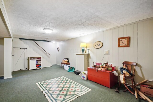 rec room featuring a textured ceiling and carpet floors