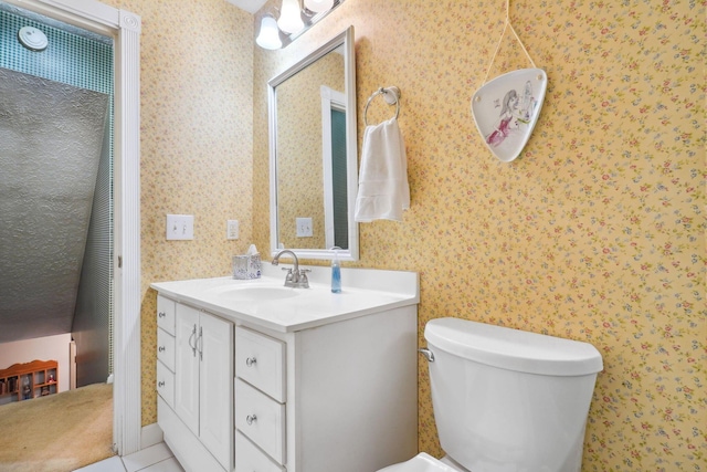 half bathroom with toilet, vanity, and wallpapered walls