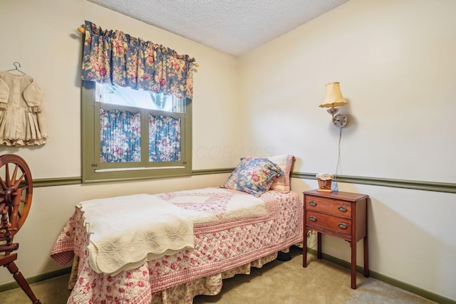 carpeted bedroom with a textured ceiling and baseboards