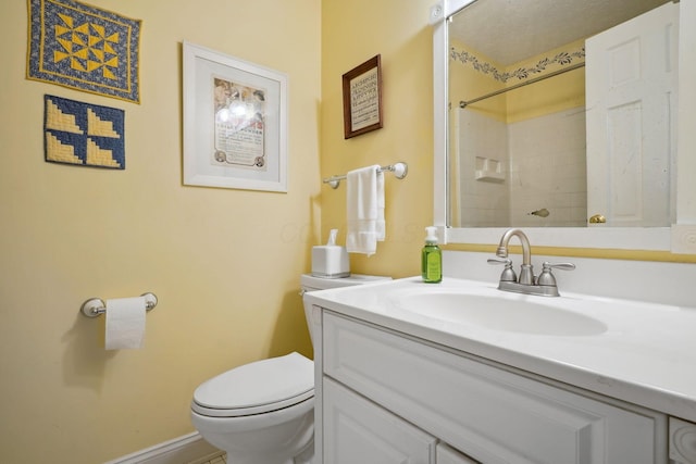 bathroom with toilet, vanity, and walk in shower