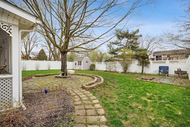 view of yard featuring an outbuilding, a fenced backyard, and a storage shed