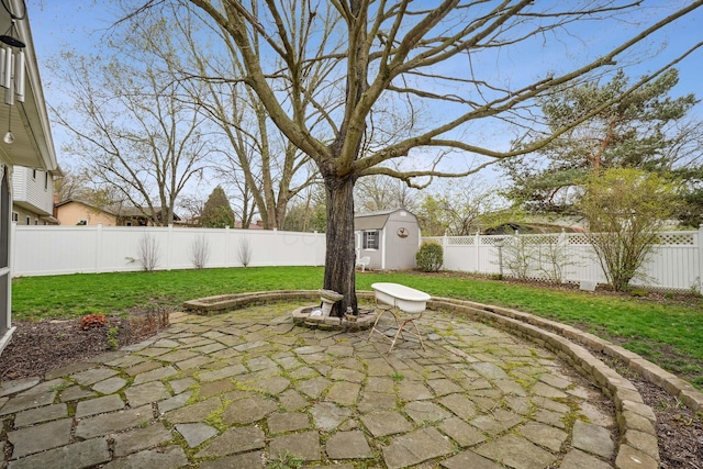 view of patio / terrace featuring an outbuilding, a fenced backyard, and a storage unit
