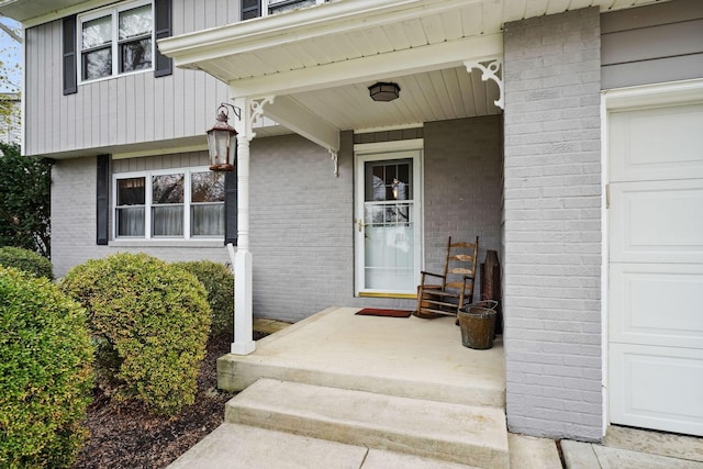 entrance to property with covered porch and brick siding
