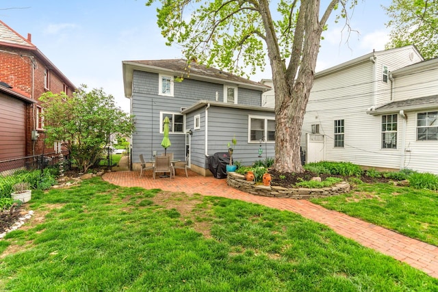 rear view of house featuring a patio, fence, and a yard