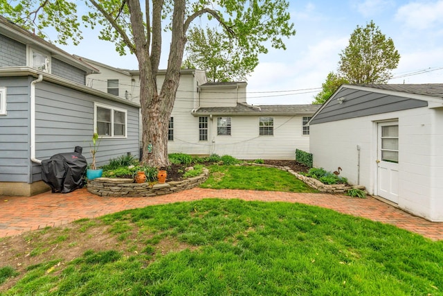 back of house with a lawn and a patio area