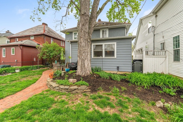 back of property featuring a yard and fence