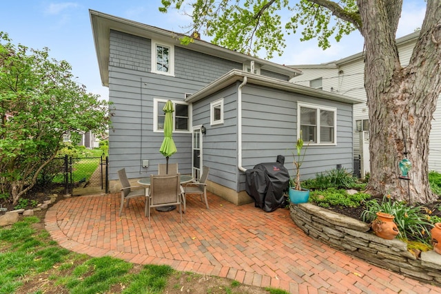 rear view of property with a patio, a gate, and fence