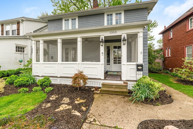 view of front of home with a chimney and a sunroom