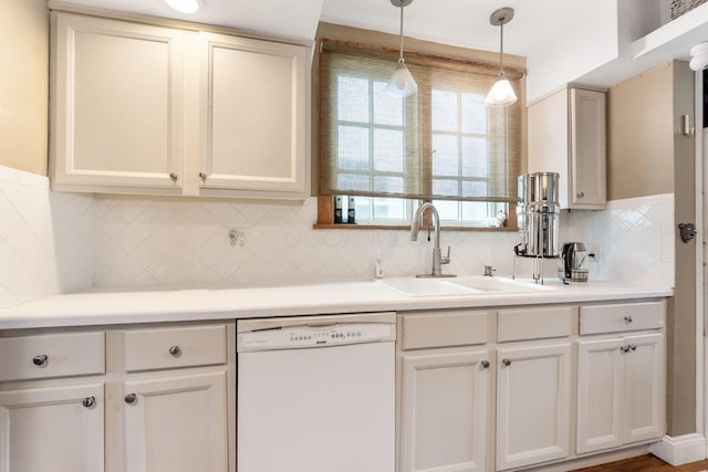 kitchen featuring a sink, light countertops, white dishwasher, decorative light fixtures, and backsplash