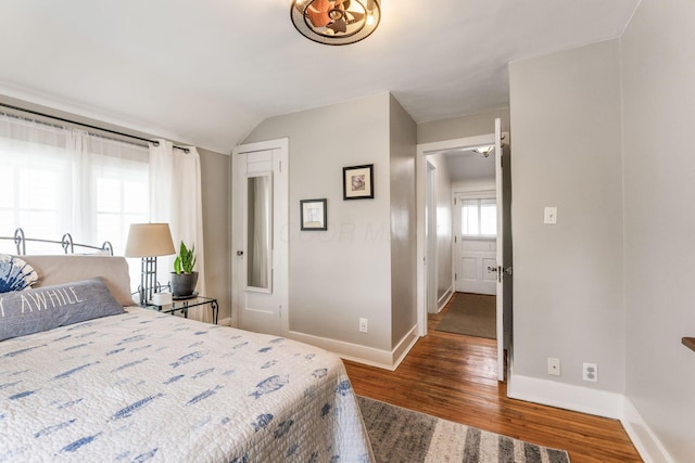 bedroom featuring wood finished floors, vaulted ceiling, and baseboards