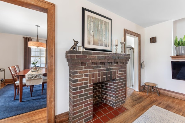 details with a brick fireplace, wood finished floors, and baseboards