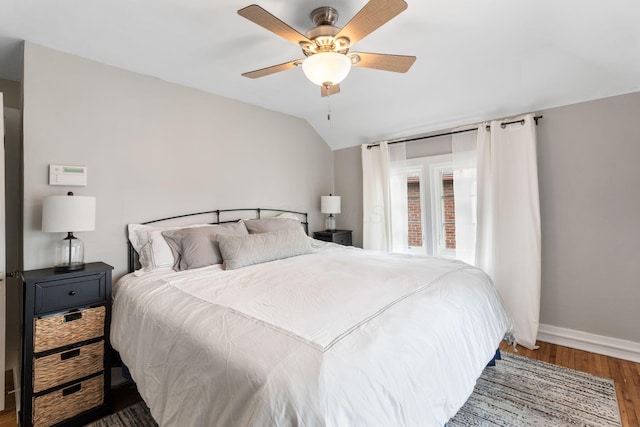 bedroom with baseboards, wood finished floors, a ceiling fan, and vaulted ceiling
