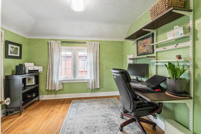 office space with wood finished floors, vaulted ceiling, and baseboards