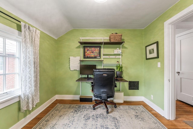 home office featuring visible vents, vaulted ceiling, wood finished floors, and baseboards