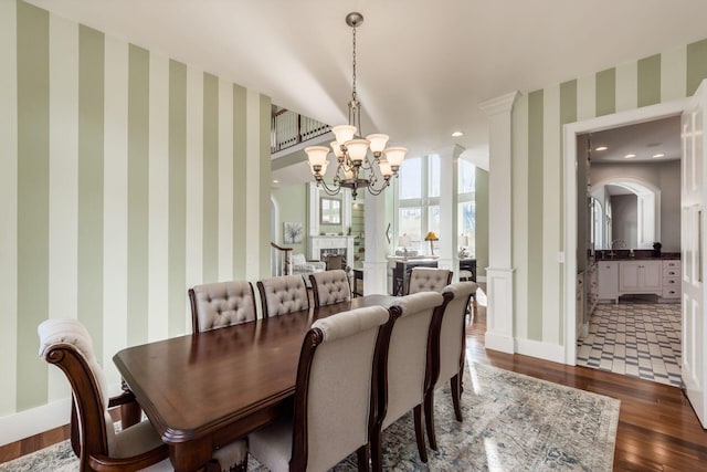 16187 Kreashbaum Rd, Rockbridge, OH 43149 - dining area featuring wood-type flooring, an inviting chandelier, wallpapered walls, and baseboards
