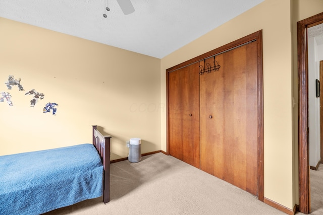 carpeted bedroom with baseboards, ceiling fan, and a closet