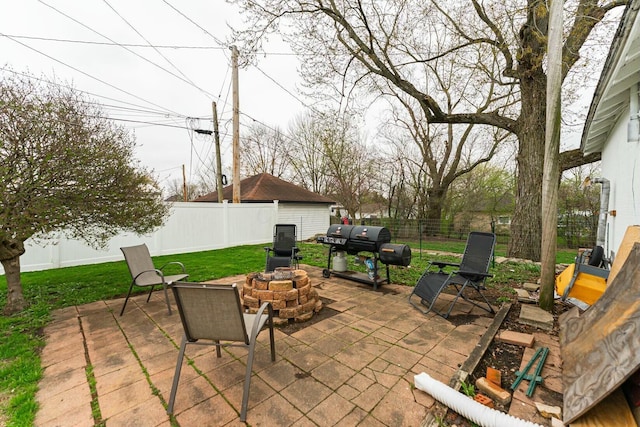 view of patio with an outdoor fire pit, area for grilling, and a fenced backyard