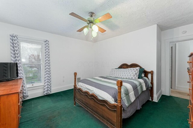 bedroom with a textured ceiling, baseboards, and carpet