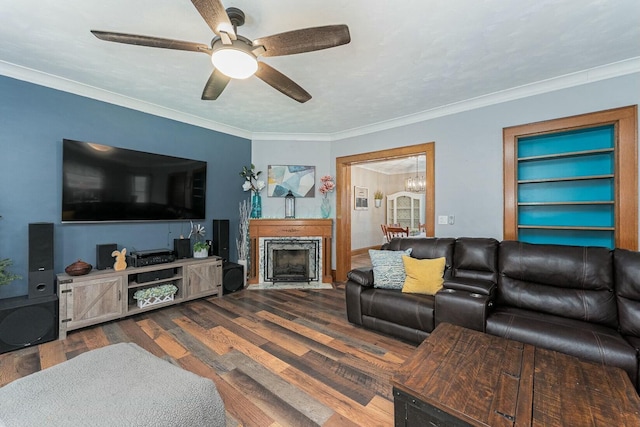 living area with a fireplace with flush hearth, crown molding, wood finished floors, and ceiling fan