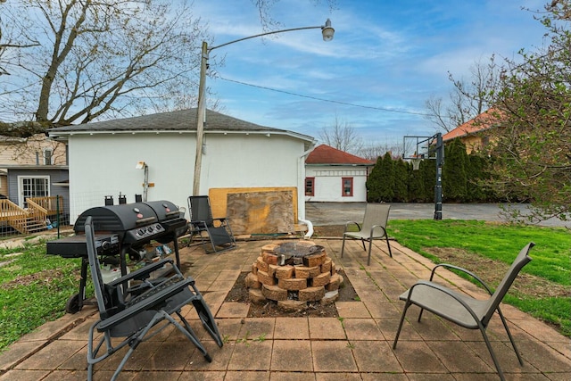 view of patio with an outdoor fire pit and an outbuilding