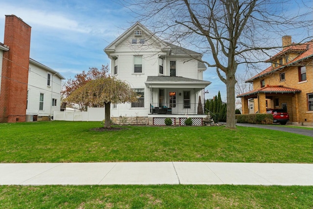 victorian-style house featuring a porch and a front lawn