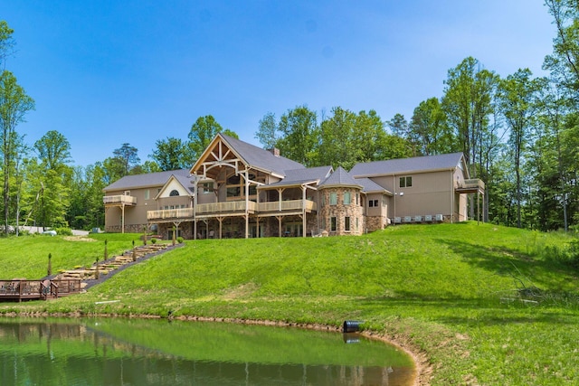 16012 State Route 678, Rockbridge, OH 43149 - rear view of house featuring stone siding, a deck with water view, a lawn, and a sunroom