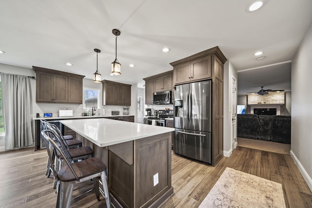 11378 Ann Dr NW, Baltimore, OH 43105 - kitchen featuring dark brown cabinetry, recessed lighting, light countertops, stainless steel appliances, and a sink